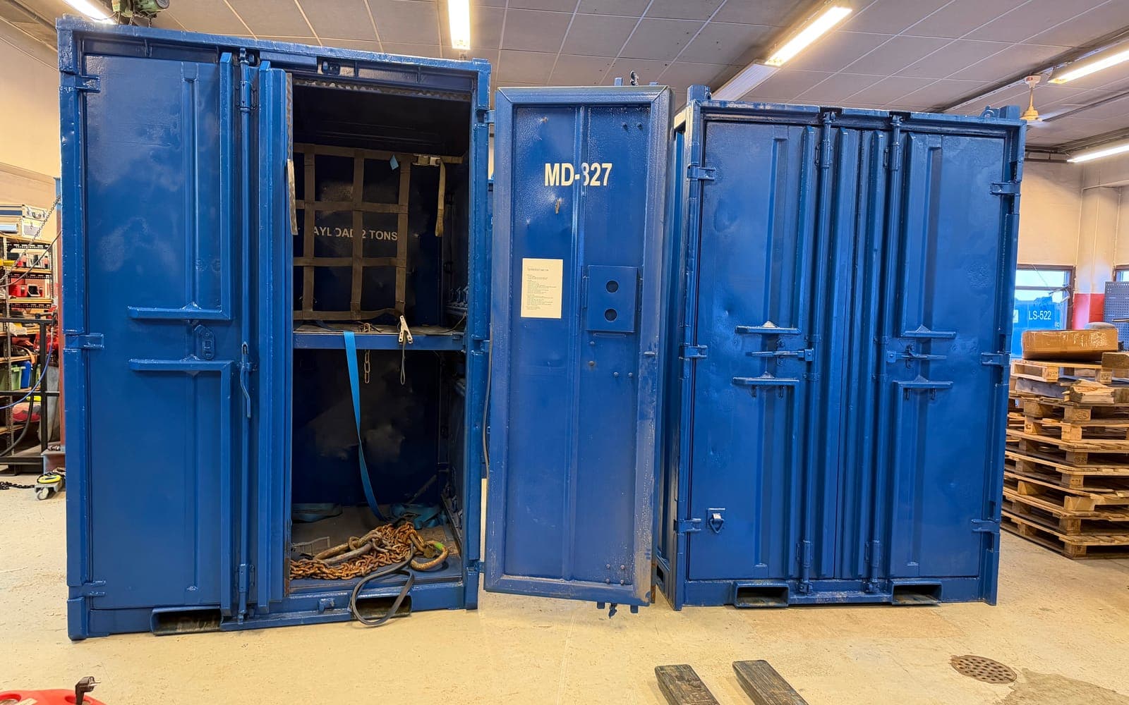 Blå offshorecontainer MD-327 med dørene åpne og kjetting og stropper inni, i containerverkstedet i Rypefjord