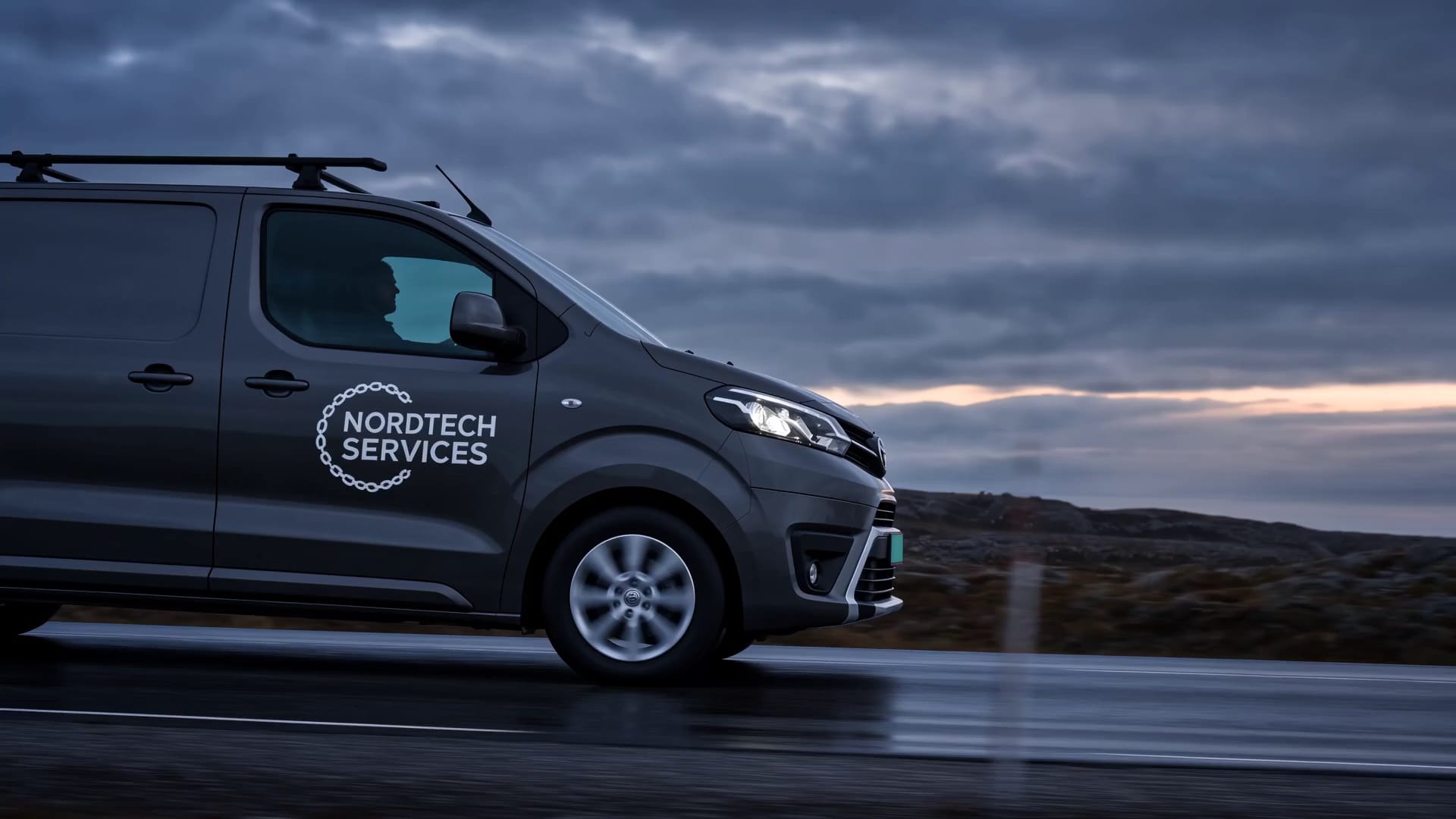 Nordtech Services' servicebil på Finnmarksveien i kveldslys, sett fra siden